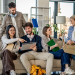 Group of diverse young adults are studying and collaborating together, using a digital tablet for their university project