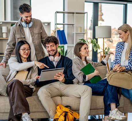 Group of diverse young adults are studying and collaborating together, using a digital tablet for their university project