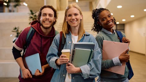 Multiracial group of happy college friends looking at camera.
